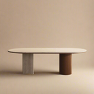 Travertine sintered stone dining table with oval top and dual wood pedestal base on beige studio background