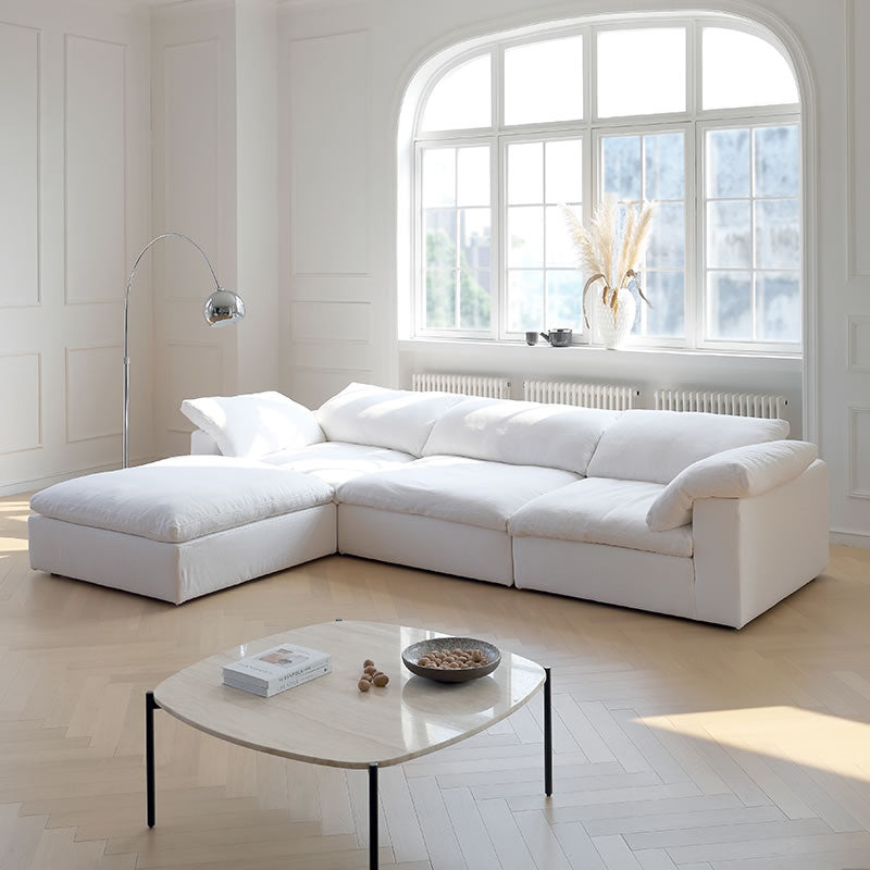 Ultra Softness Modular Cloud Sofa in natural linen with chaise lounge styled in a bright living room with large arched window