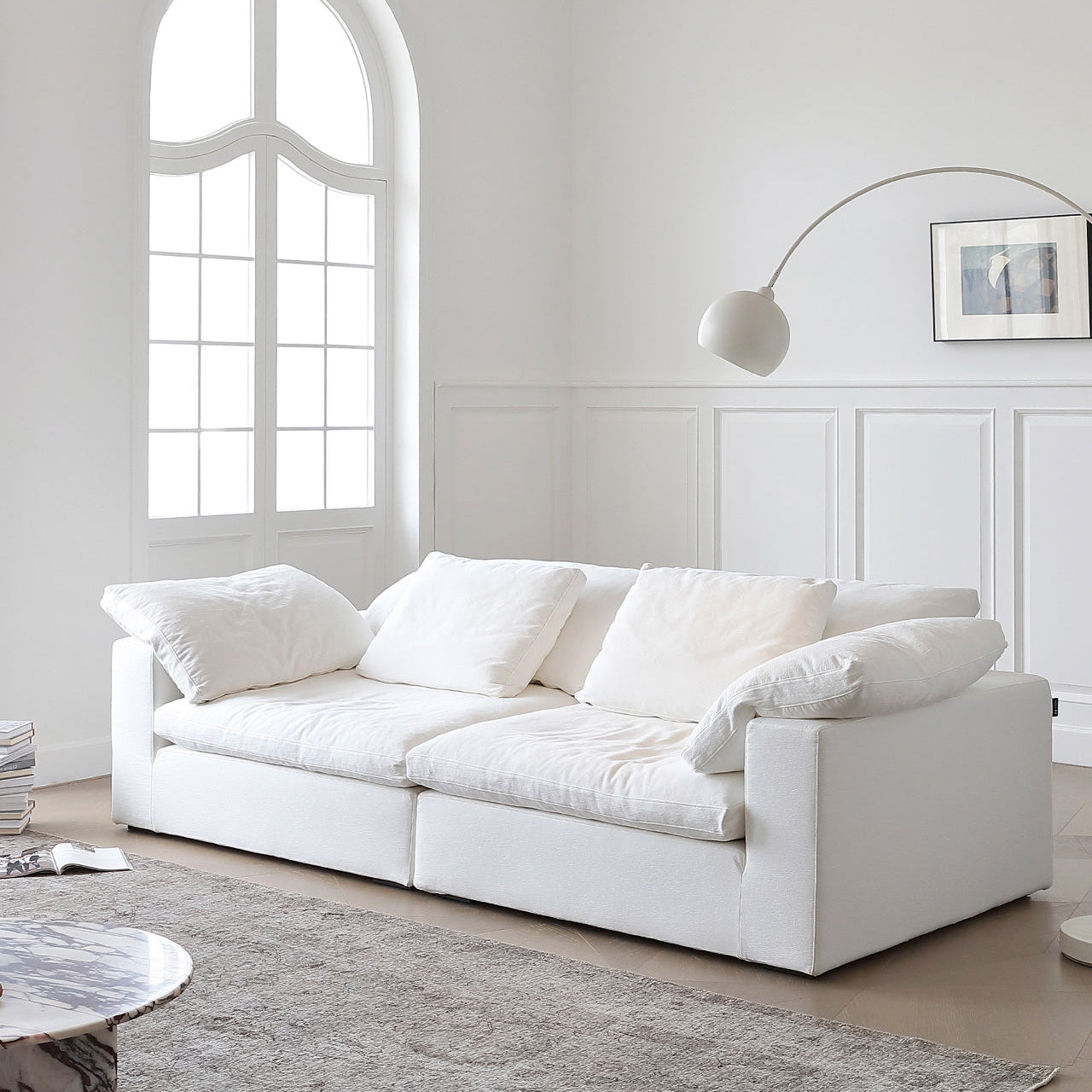 Ultra Softness Modular Cloud Sofa in natural linen with plush cushions styled in a bright living room with arched window and modern decor
