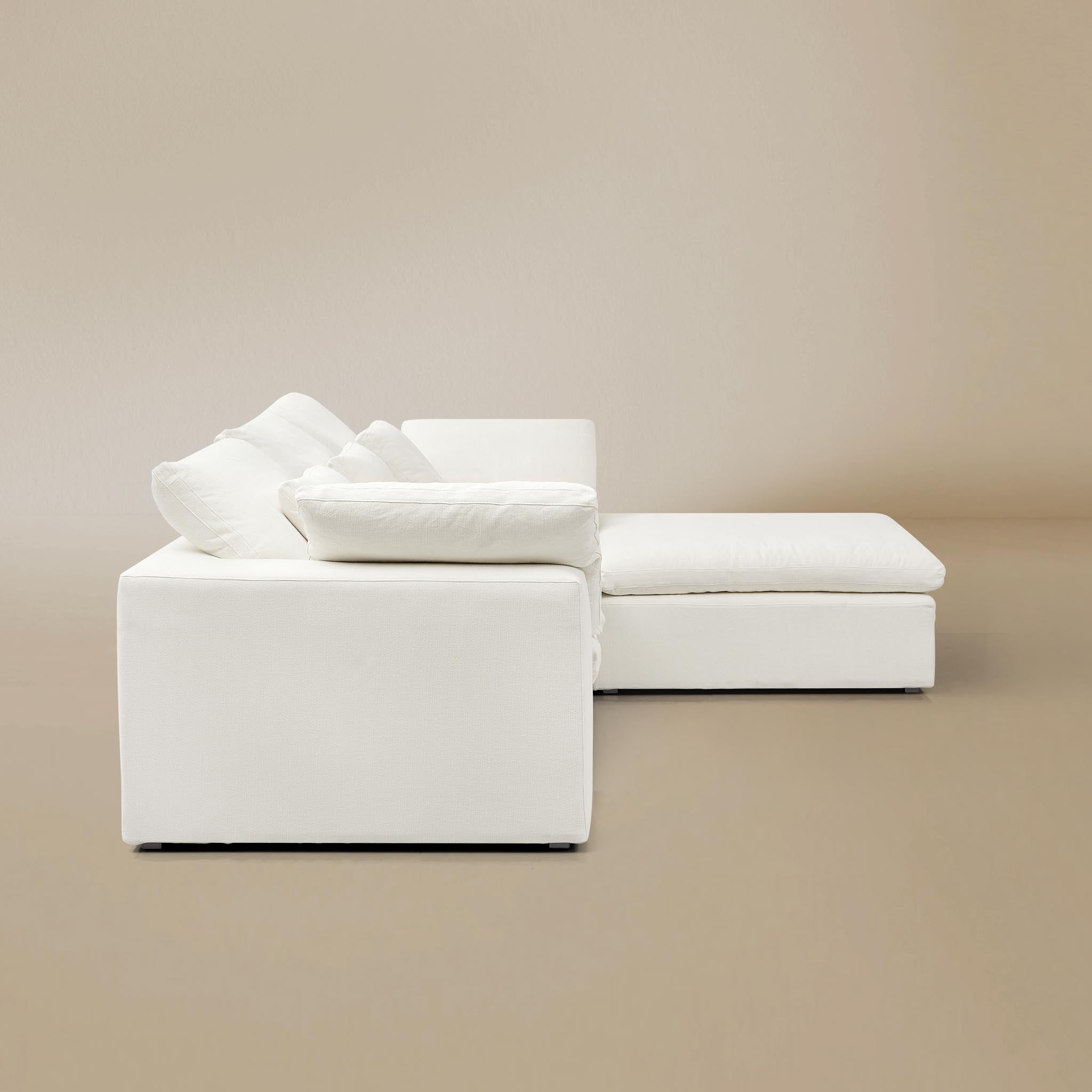 Side view of ultra softness modular sofa two seater with ottoman on a beige studio  background
