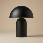 Front view of the Umbra black dome table lamp featuring a sleek matte finish and modern mushroom silhouette.