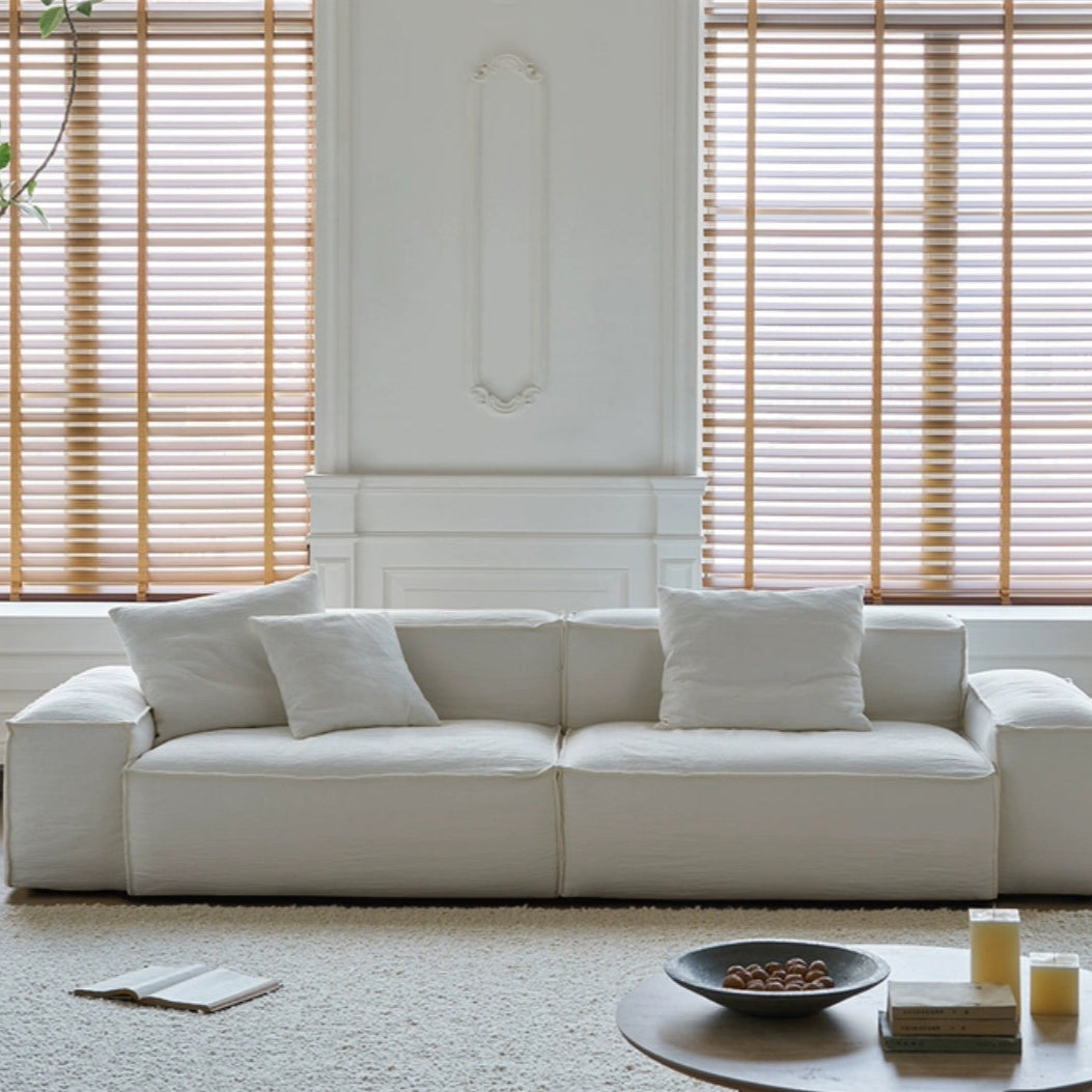 Front view of Whisper Breathable Cotton Sofa 2 seater in white breathable cotton muslin fabric styled in a minimalist living room with soft natural light and neutral tones