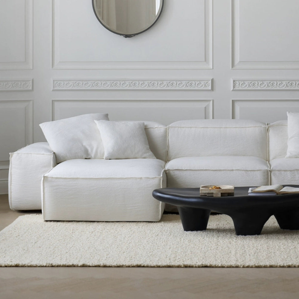 Whisper Breathable Cotton Sofa 3 seater with left chaise in white breathable cotton muslin fabric styled in modern living room with black coffee table and textured rug