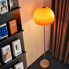 Yellow Dome Glass Standing Floor Lamp illuminating a cozy reading corner with bookshelf and brown curtains