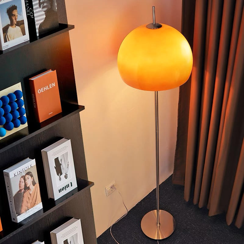 Yellow Dome Glass Standing Floor Lamp illuminating a cozy reading corner with bookshelf and brown curtains